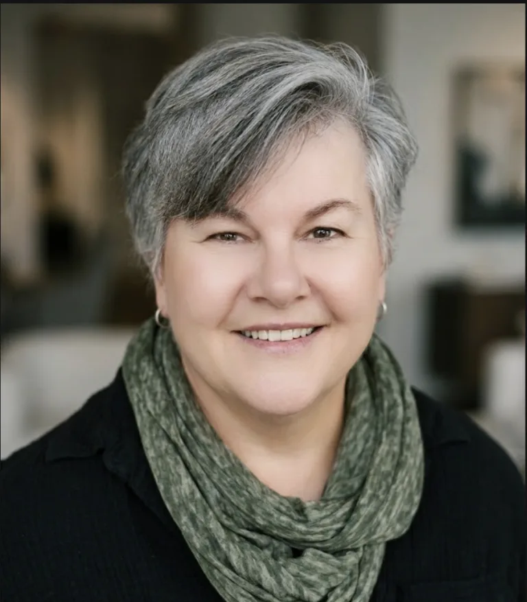 Portrait of Becky DeGrossa, founder of CounselingWise, smiling with short gray hair and a green scarf