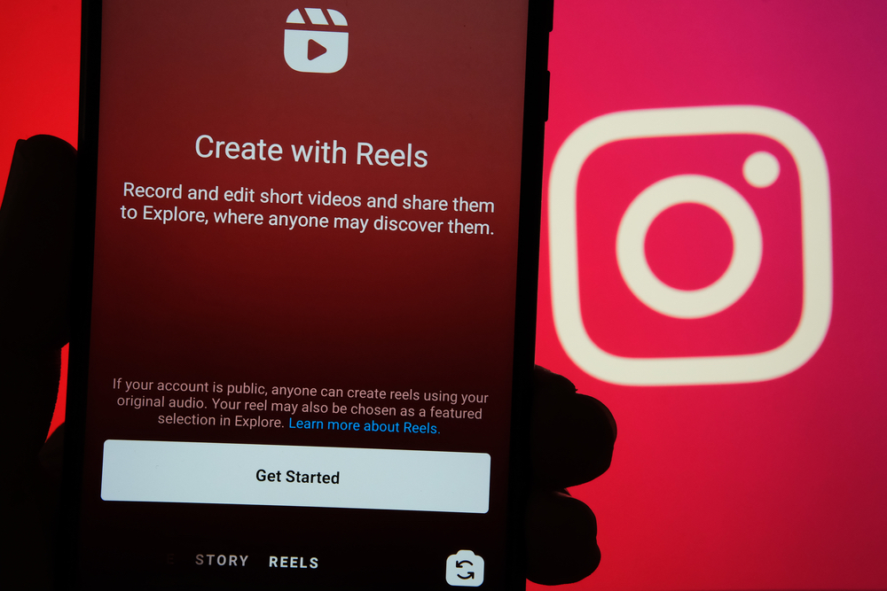 Phone showing the Create with Reels screen beside the Instagram logo