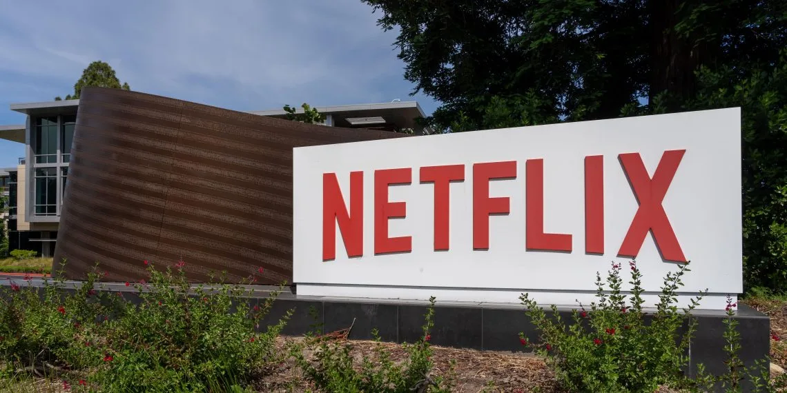 The red Netflix sign at the company headquarters building under a clear sky